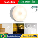 Luminária LED inteligente sem fio com sensor de movimento instalada em um armário, iluminando automaticamente o ambiente.